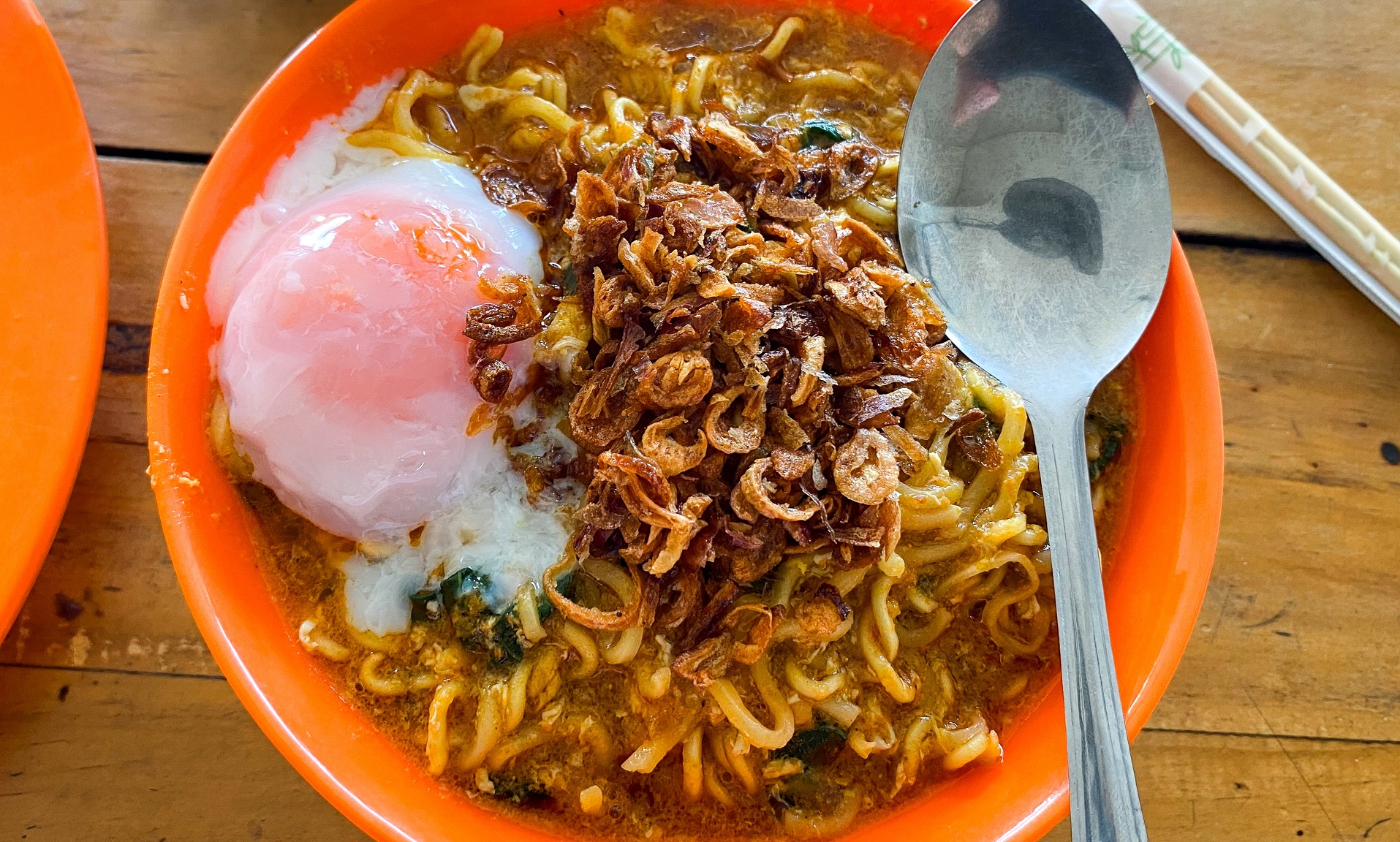 Semangkuk Mie Bangladesh dengan kuah rempah yang kental, dihiasi daun ketumbar segar dan irisan jeruk nipis